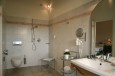 Geräumiges Badezimmer mit rollstuhlgängiger Dusche, Badewanne mit Stützstange und geeignetem WC und Lavabo