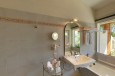 Geräumiges Badezimmer mit rollstuhlgängiger Dusche, Badewanne mit Stützstange und geeignetem WC und Lavabo